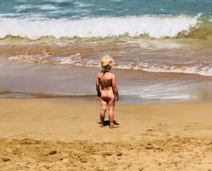Kleines Kind nackt am Strand